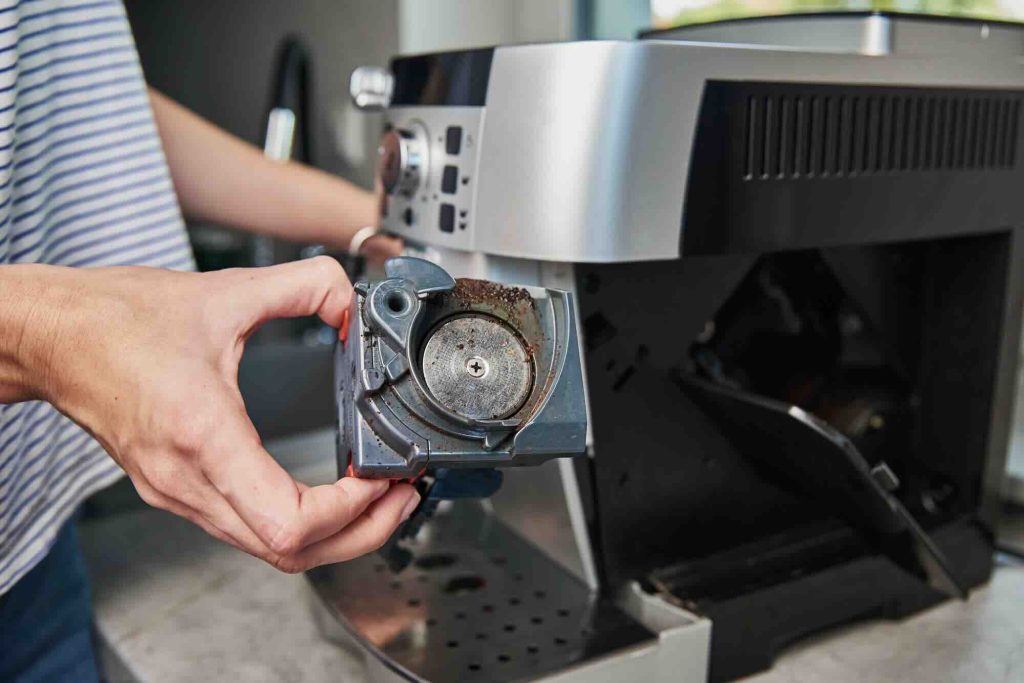 a woman cleaning a coffee machine